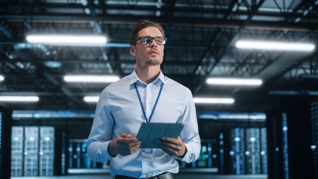 An IT auditor with a tablet visually inspects a server room