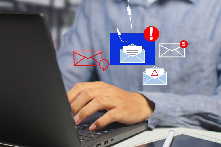 A man at a laptop with images of emails superimposed over his hands.