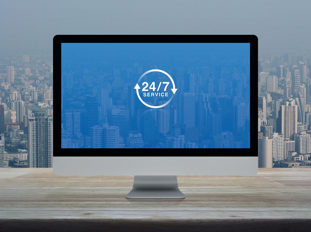 Computer screen showing 24/7 IT system monitoring dashboard with real-time alerts and metrics.