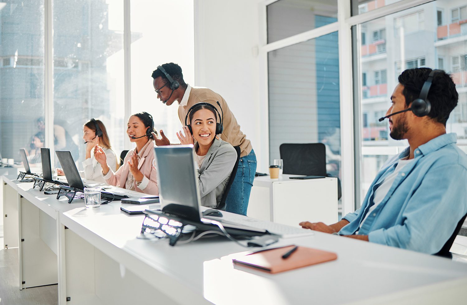 A group of employees on computers with headsets.